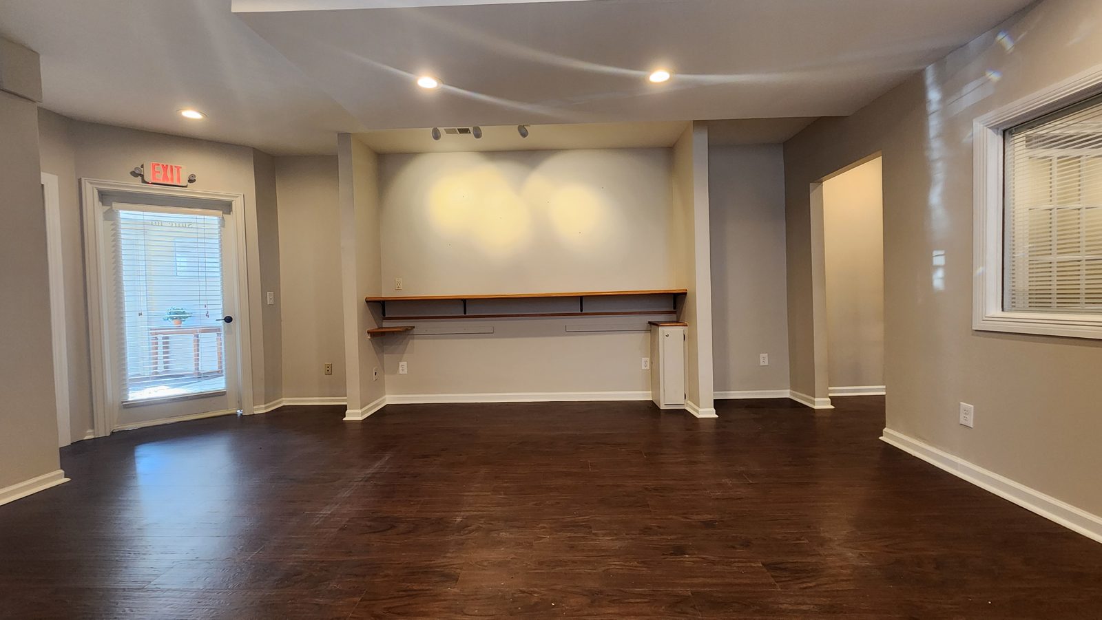 Suite 101 back wall with built-in shelving and an exterior door